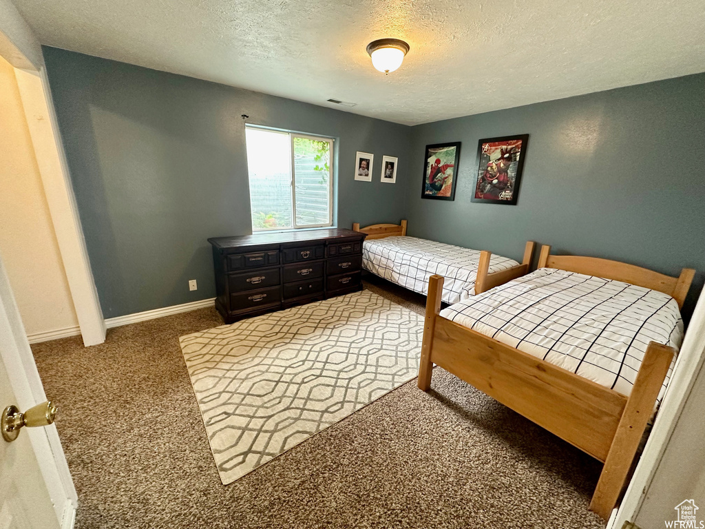 Carpeted bedroom featuring a textured ceiling