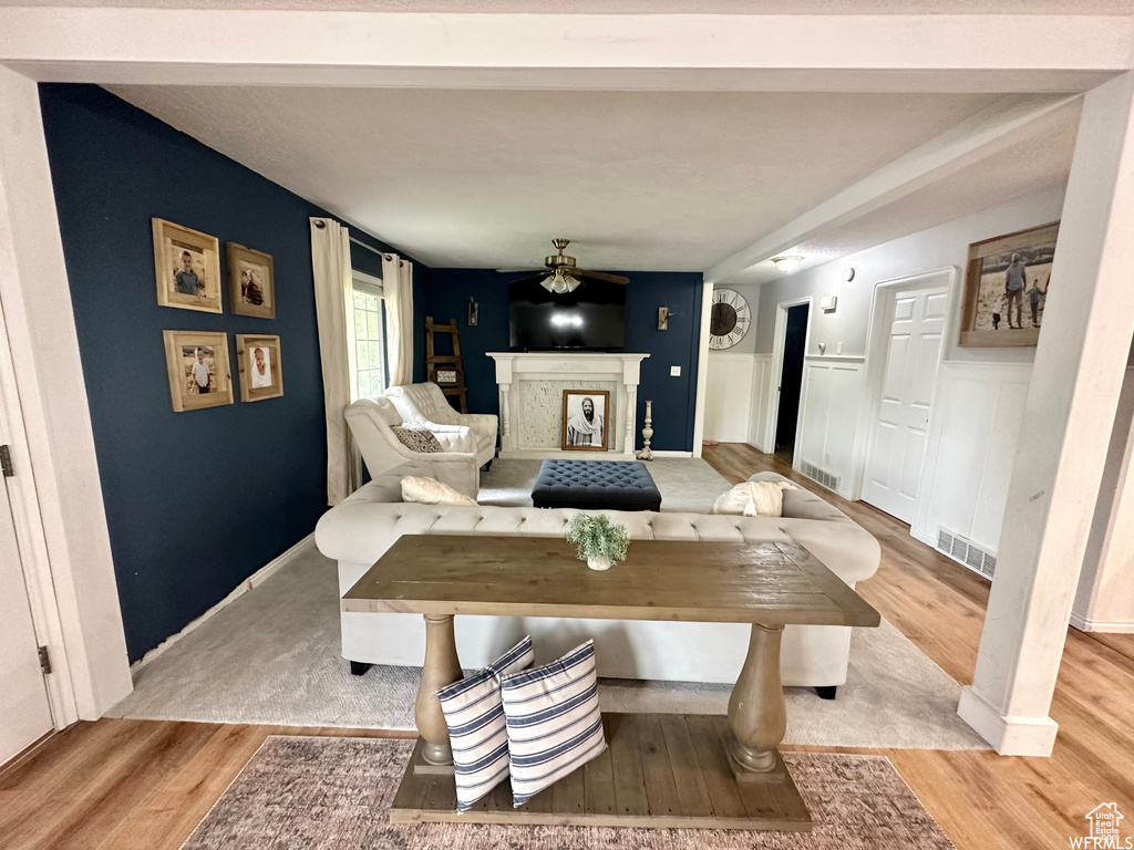 Dining space with a fireplace, light wood-type flooring, and ceiling fan