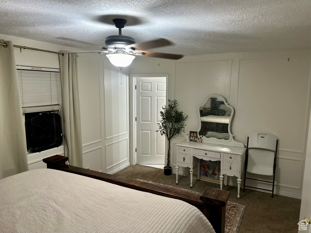 Carpeted bedroom with a textured ceiling and ceiling fan