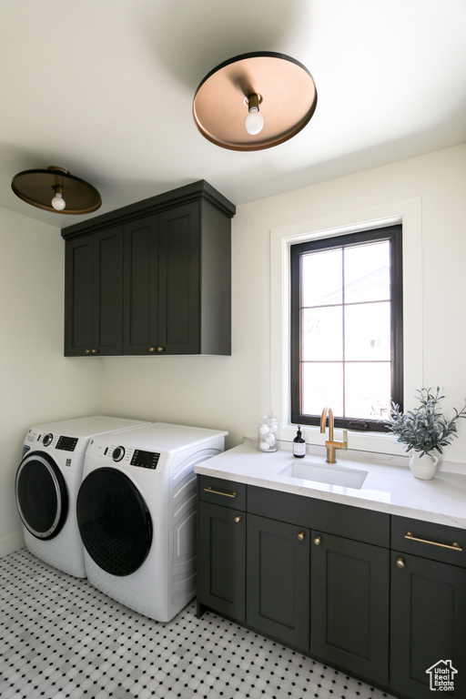 Washroom featuring sink, cabinets, and independent washer and dryer