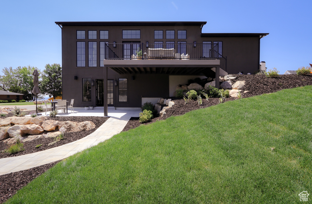 Rear view of house featuring a lawn and a patio area