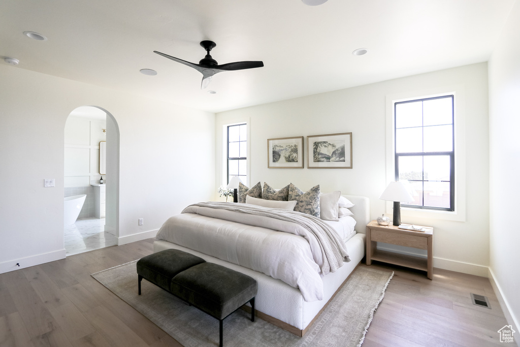 Bedroom featuring multiple windows, ceiling fan, and hardwood / wood-style floors