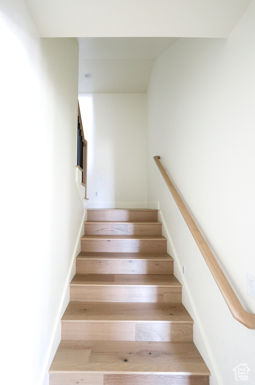 Staircase with light hardwood / wood-style flooring