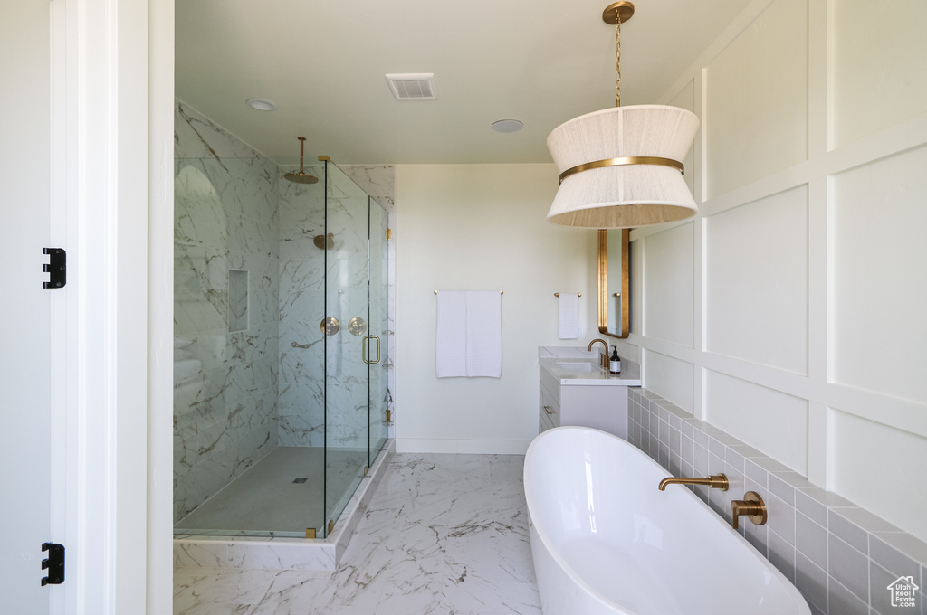 Bathroom featuring tile patterned flooring, plus walk in shower, and vanity