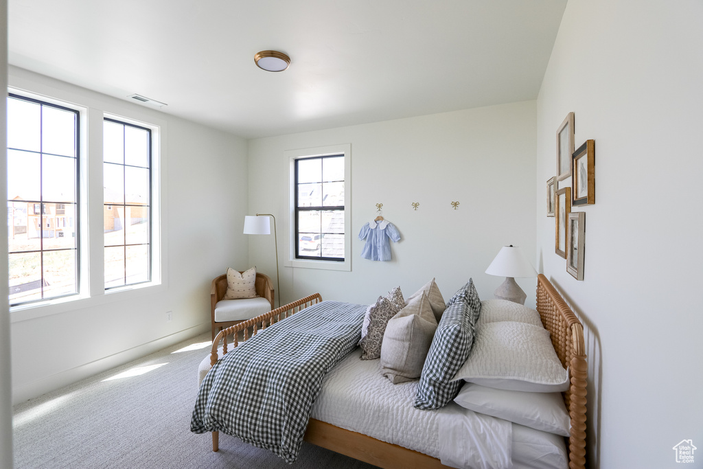 Bedroom with multiple windows and carpet floors