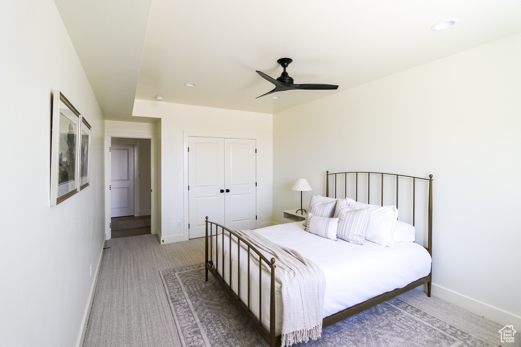 Carpeted bedroom with a closet and ceiling fan