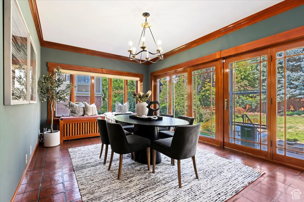 Dining space featuring a notable chandelier and crown molding