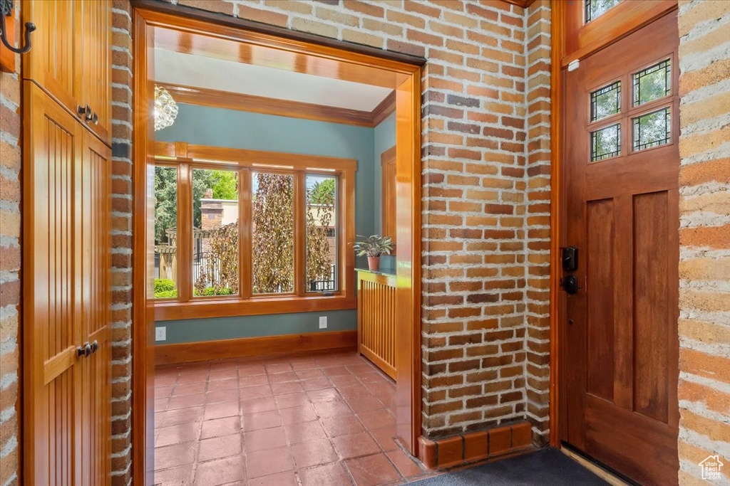 Entrance foyer featuring crown molding and a healthy amount of sunlight