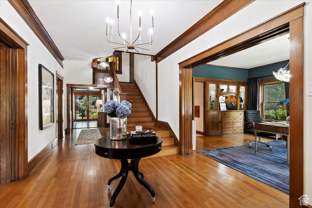 Interior space with crown molding, hardwood / wood-style floors, and a notable chandelier