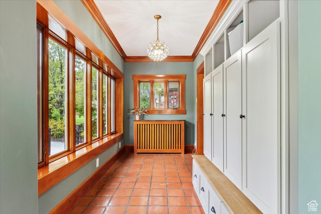 Mudroom featuring a chandelier, radiator heating unit, light tile patterned flooring, and ornamental molding