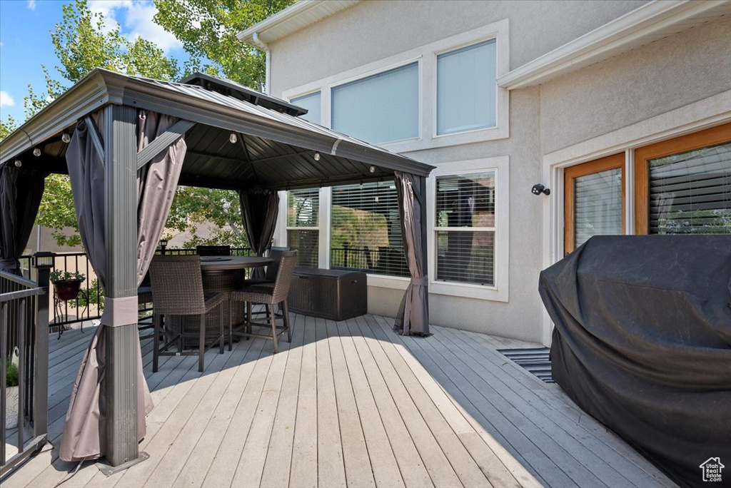 Wooden deck featuring grilling area and a gazebo