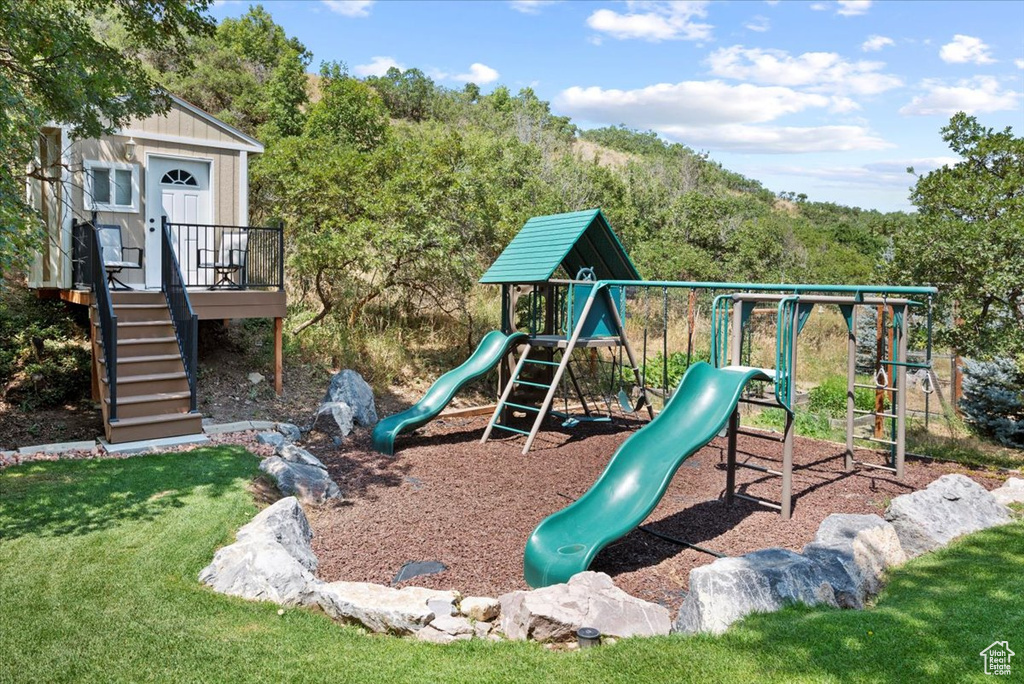 View of play area featuring a deck and a lawn