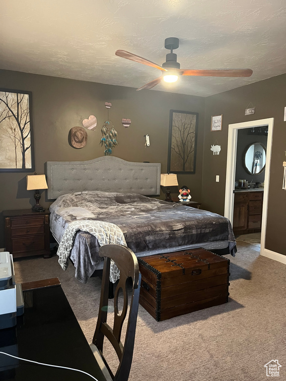 Bedroom with ensuite bath, ceiling fan, and carpet