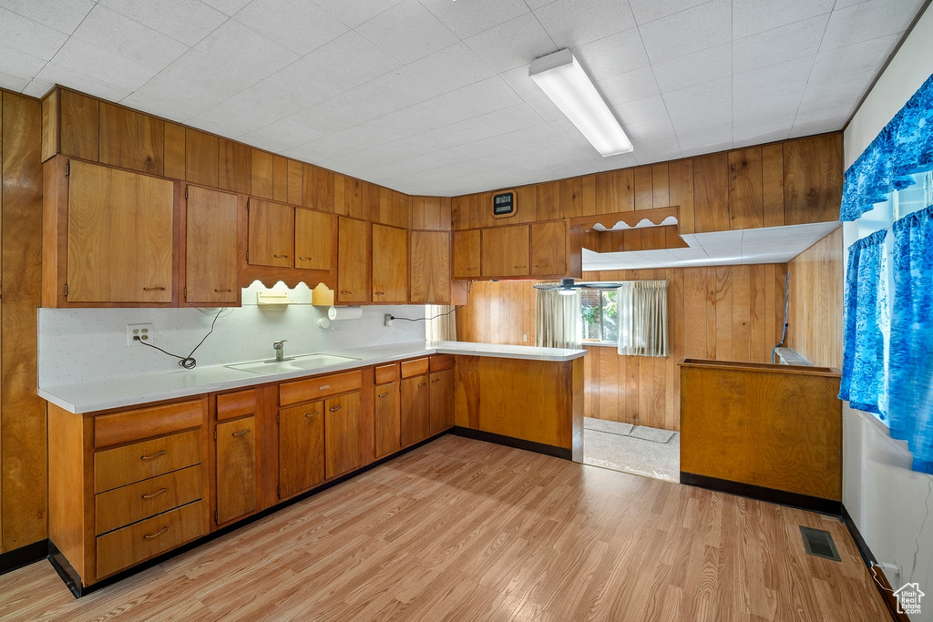 Kitchen with sink, light wood-type flooring, and kitchen peninsula