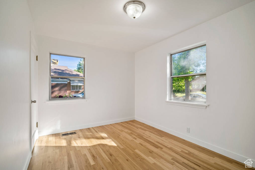 Empty room with a healthy amount of sunlight and light wood-type flooring