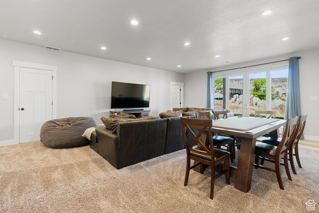 Carpeted dining area featuring french doors