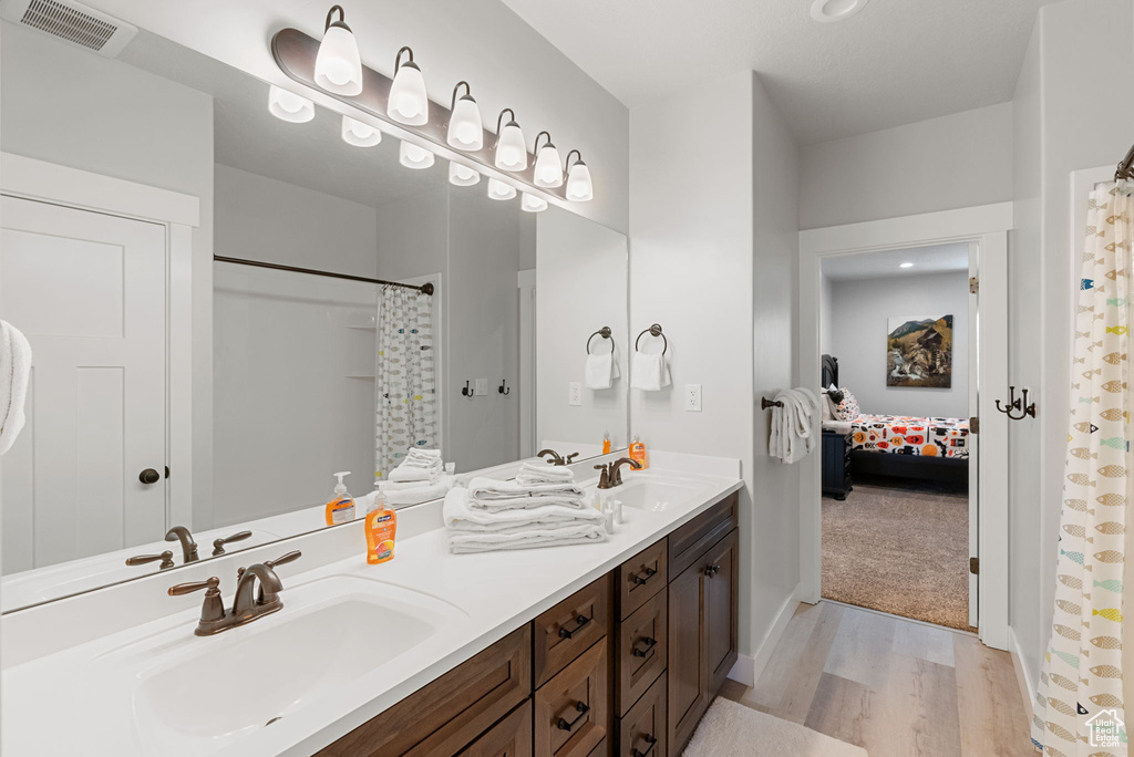 Bathroom featuring double vanity and hardwood / wood-style floors