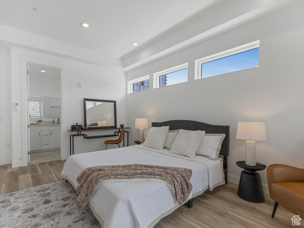 Bedroom with ensuite bathroom and light wood-type flooring