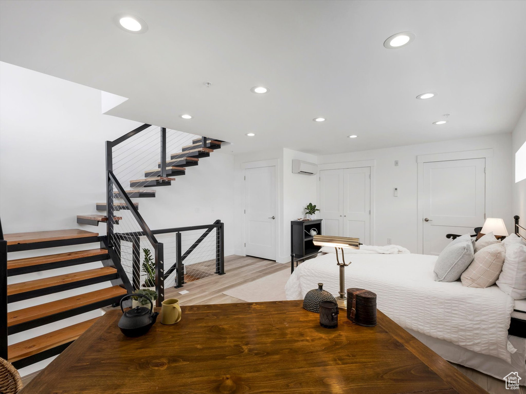 Bedroom featuring a wall mounted air conditioner and light wood-type flooring