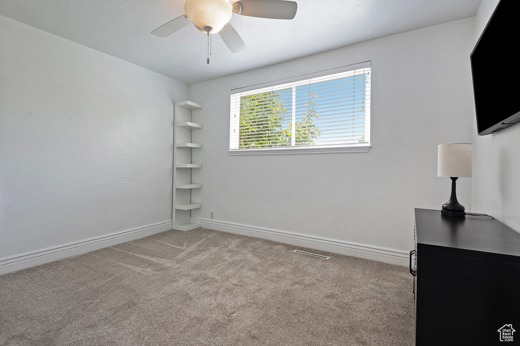 Interior space featuring light carpet and ceiling fan