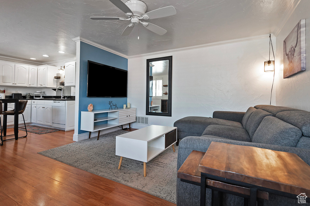 Living room with crown molding, ceiling fan, and hardwood / wood-style floors