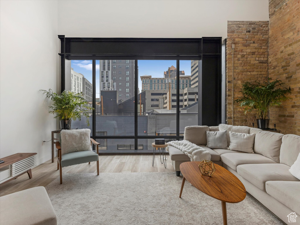 Living room with wood-type flooring and brick wall