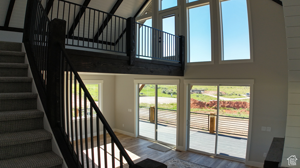 Stairs featuring light hardwood / wood-style flooring and a high ceiling