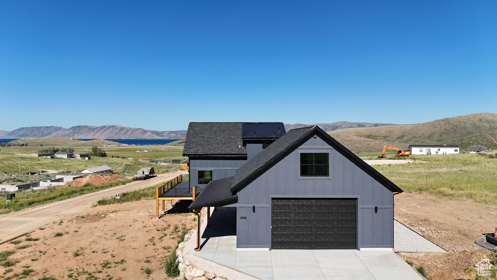 View of front of home with a mountain view and a garage