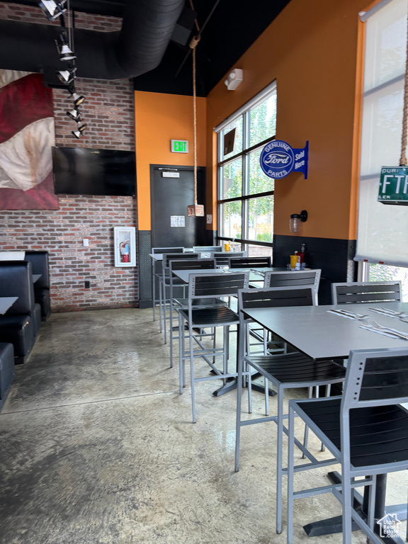 Dining room with concrete flooring and brick wall