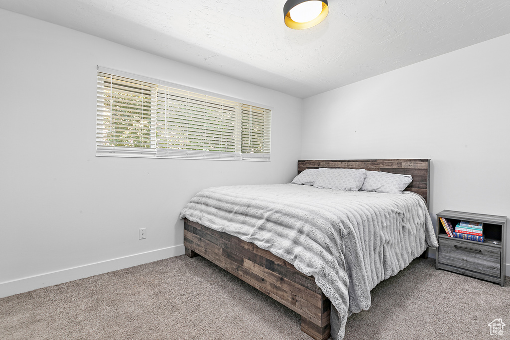 Bedroom featuring light carpet