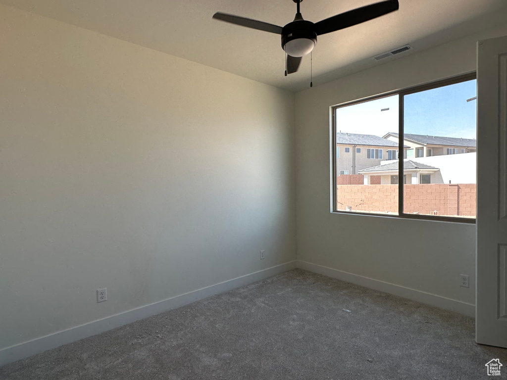 Spare room with ceiling fan and carpet