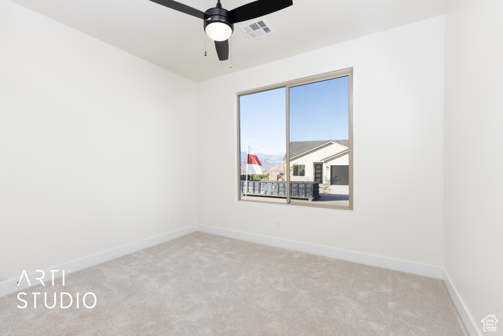 Carpeted empty room featuring ceiling fan