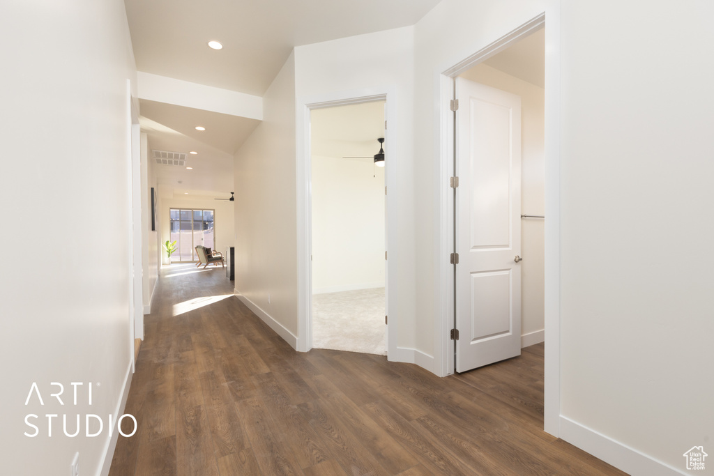 Hall featuring dark wood-type flooring and vaulted ceiling