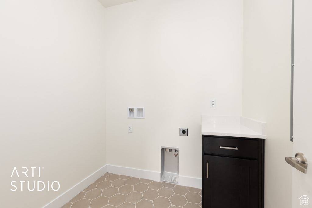 Laundry room with electric dryer hookup, washer hookup, cabinets, and light tile patterned floors