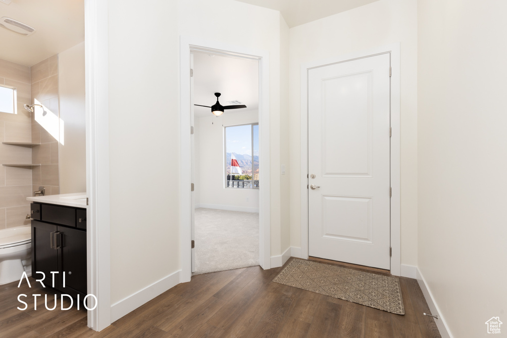 Interior space with ceiling fan and dark hardwood / wood-style floors