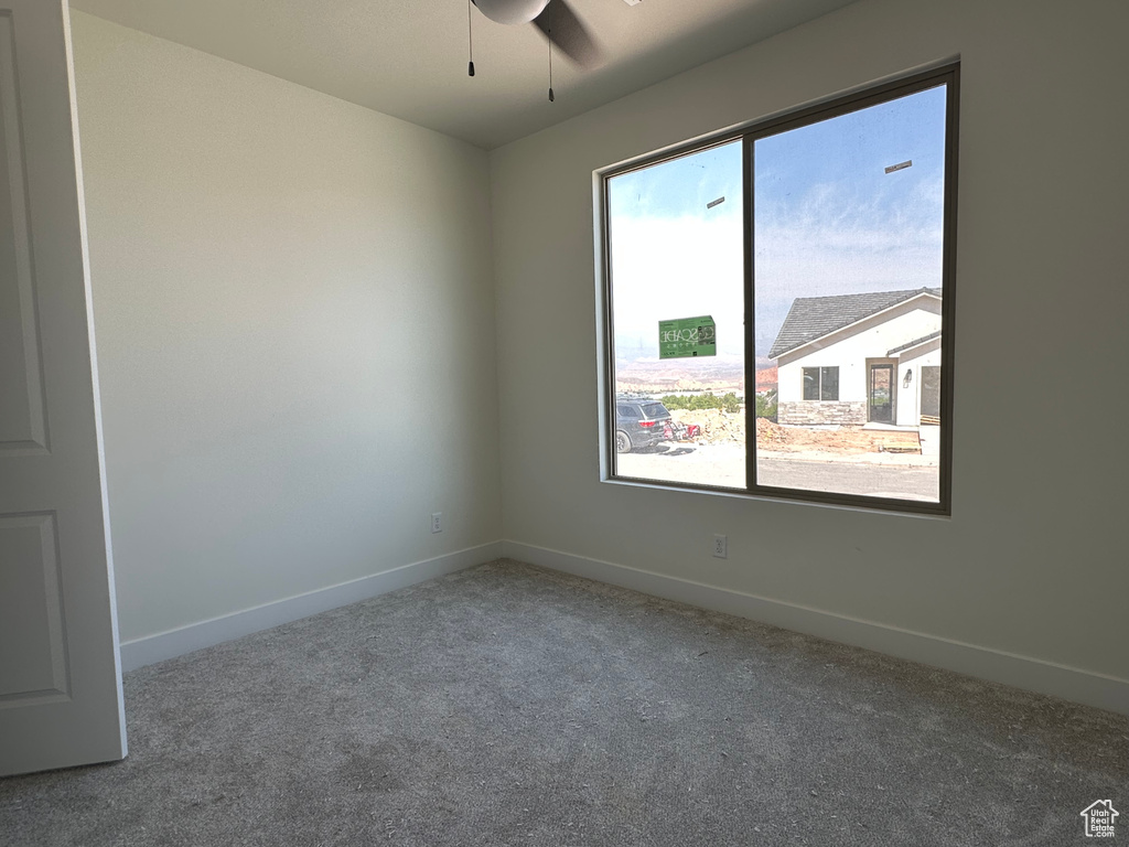 Spare room with ceiling fan and carpet