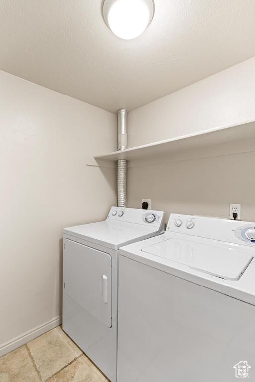 Washroom featuring light tile patterned flooring and independent washer and dryer