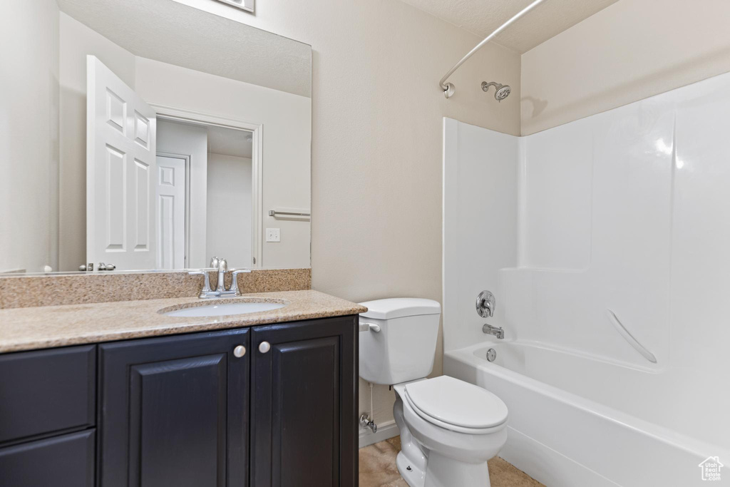 Full bathroom featuring shower / tub combination, vanity, tile patterned floors, and toilet