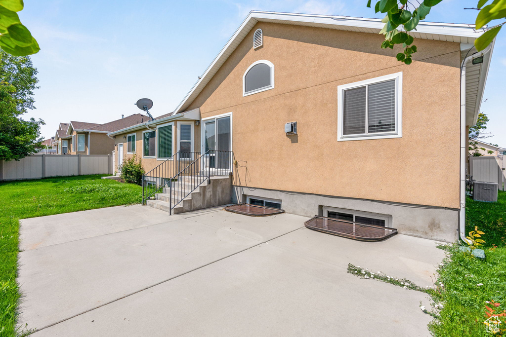 Back of house with a patio area and a yard