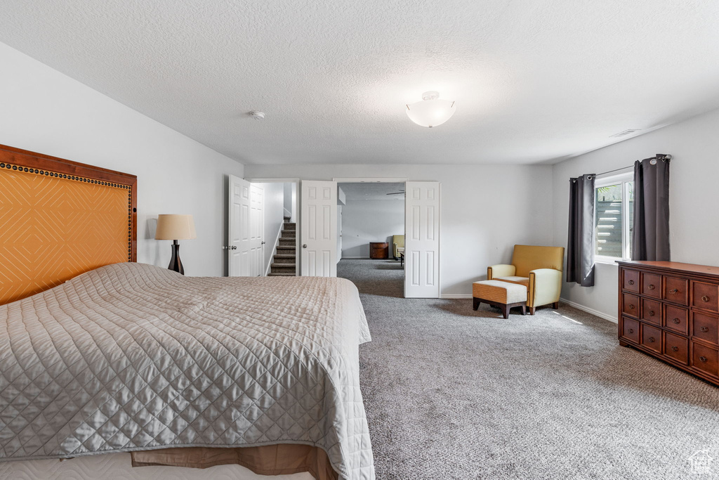 Bedroom featuring carpet and a textured ceiling