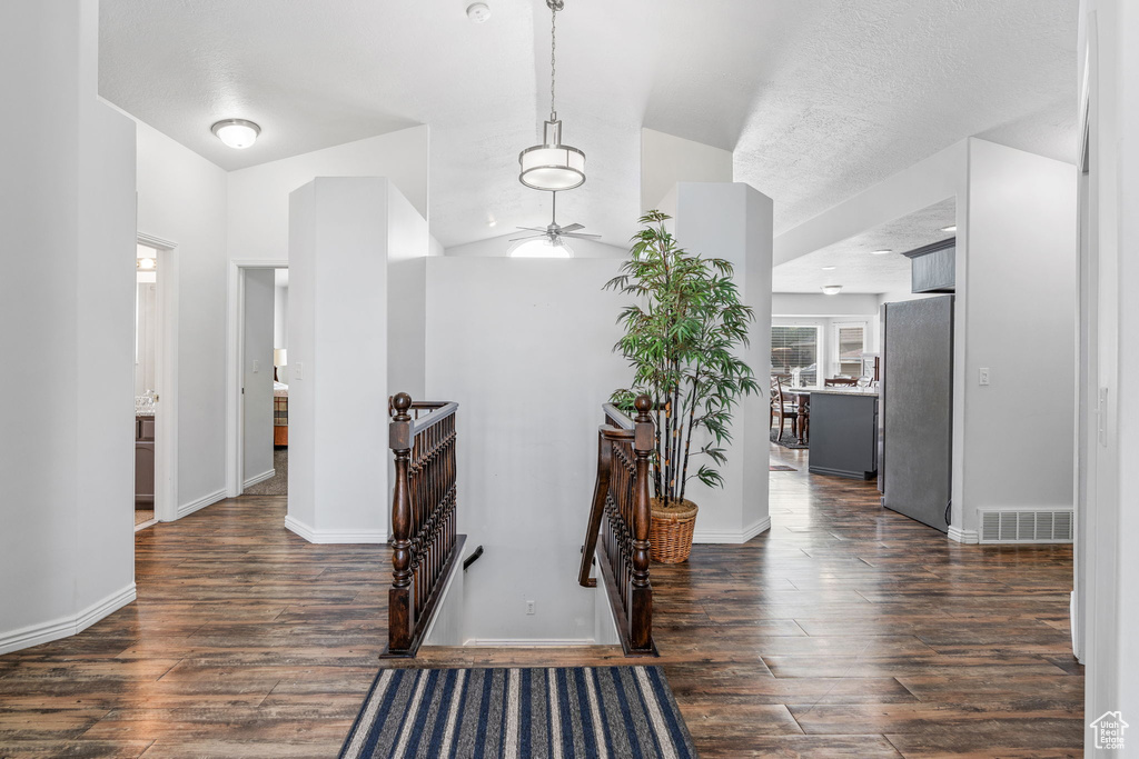 Hall with dark wood-type flooring and lofted ceiling