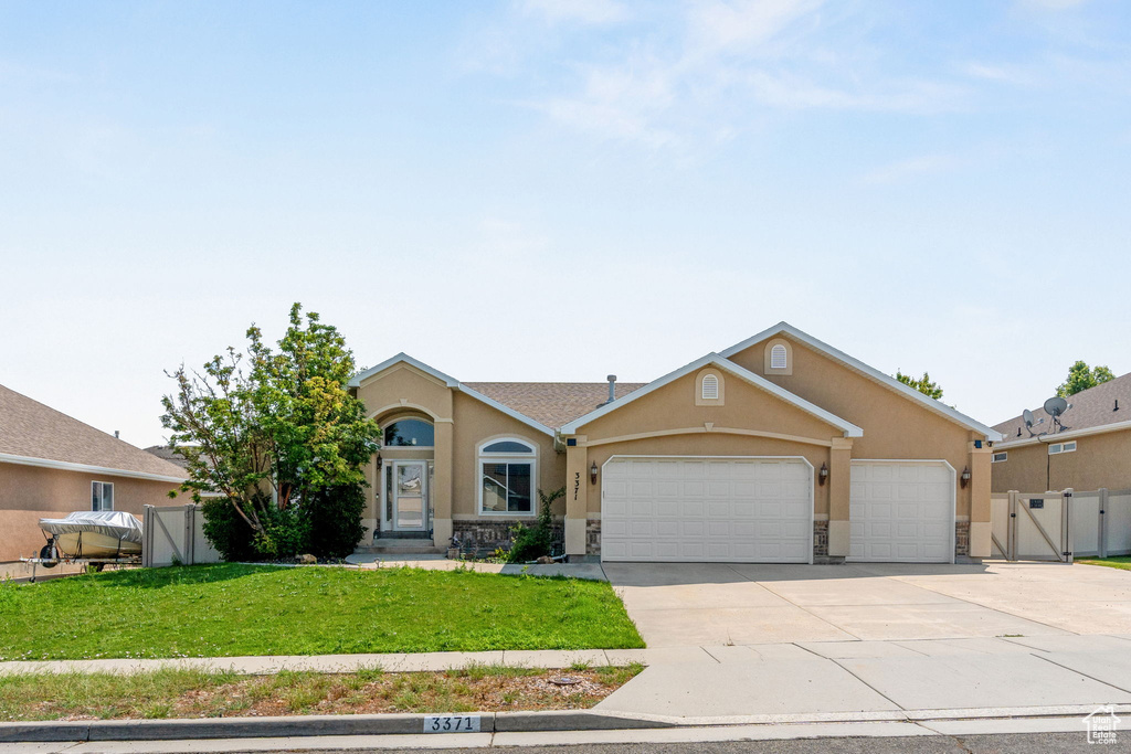 Ranch-style house featuring a garage and a front yard