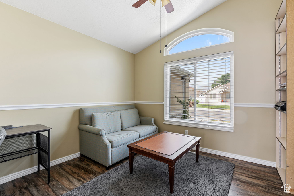 Living room with lofted ceiling, ceiling fan, and dark hardwood / wood-style floors