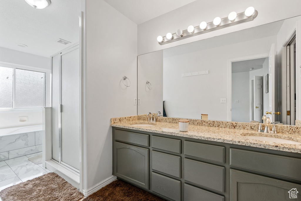 Bathroom with shower with separate bathtub, tile patterned floors, and dual bowl vanity