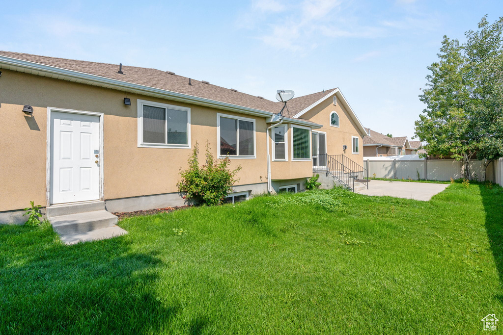 Back of house with a yard