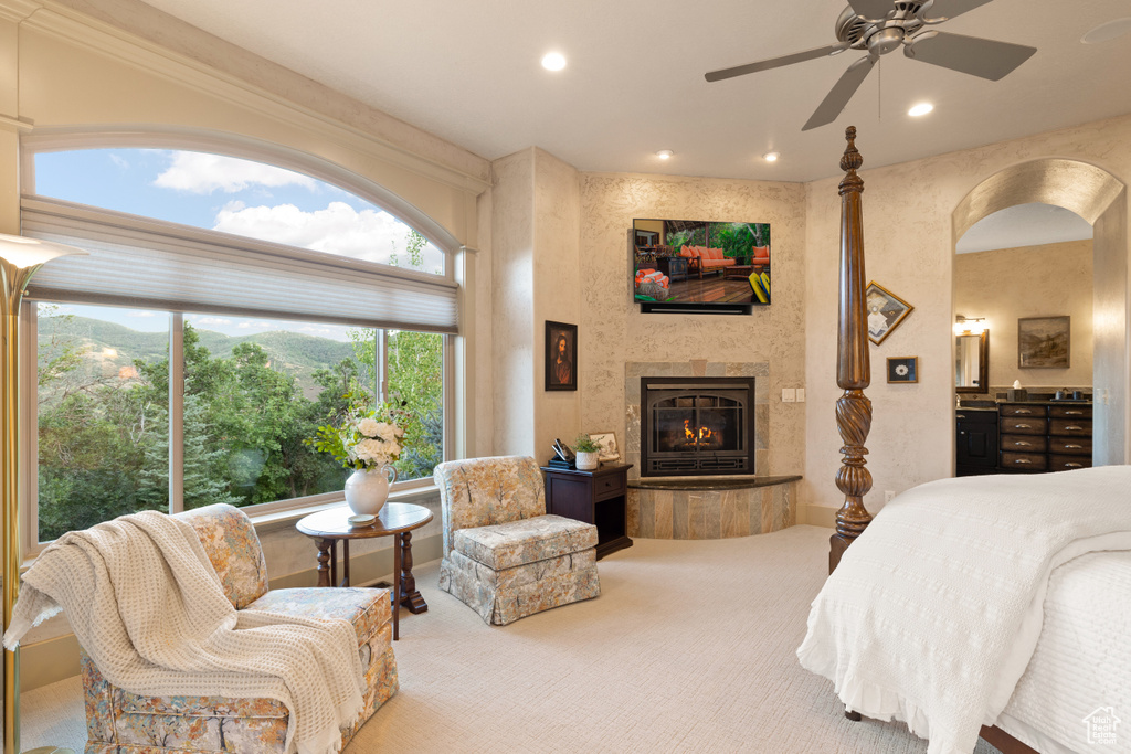 Carpeted bedroom featuring a fireplace and ceiling fan