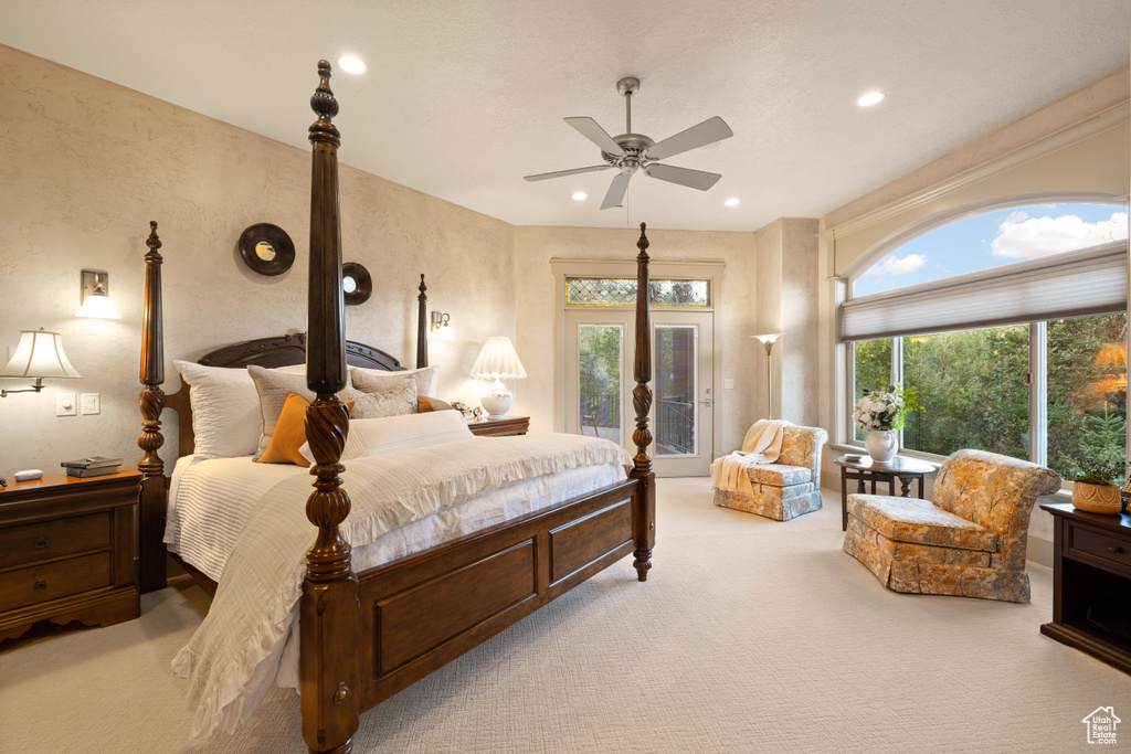 Carpeted bedroom with french doors, multiple windows, access to exterior, and ceiling fan