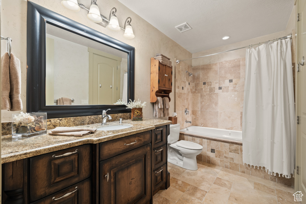 Full bathroom featuring vanity, tile patterned floors, toilet, and shower / tub combo