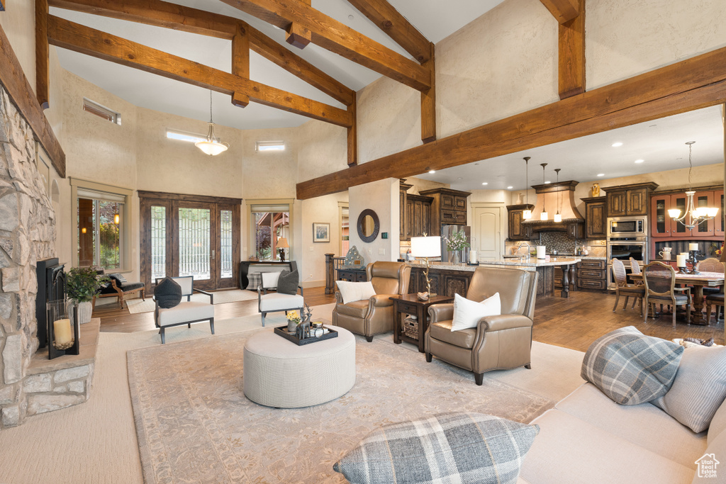 Living room with an inviting chandelier, light hardwood / wood-style flooring, and high vaulted ceiling