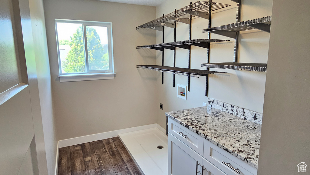 Washroom featuring electric dryer hookup, dark hardwood / wood-style flooring, cabinets, and hookup for a washing machine